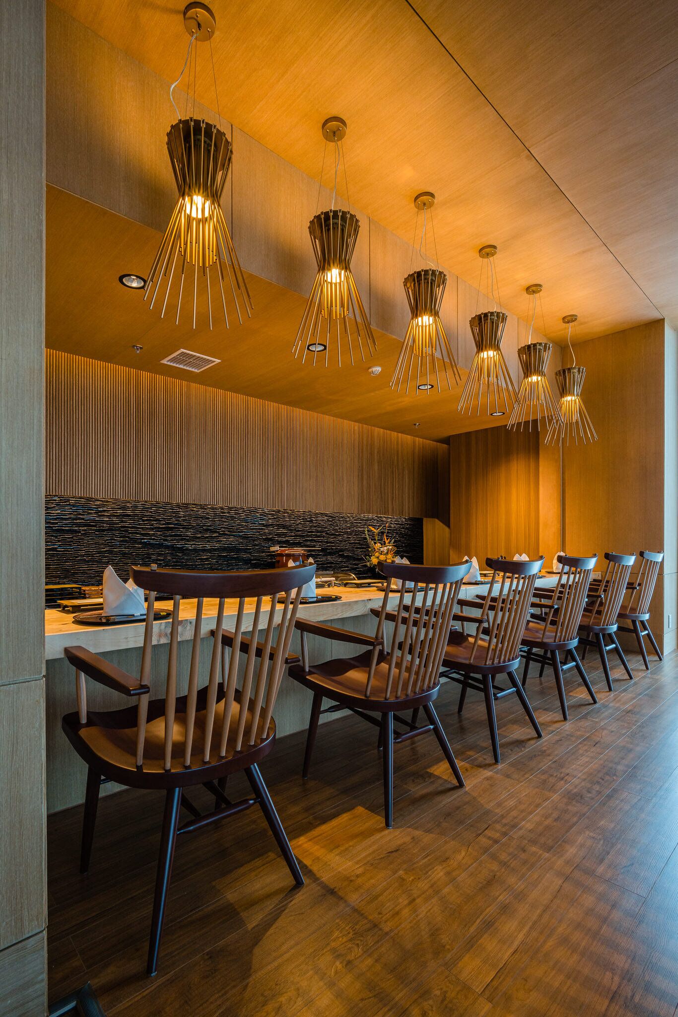 A modern dining area with wooden chairs and a central island.