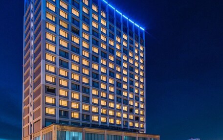 A hotel building with a swimming pool and outdoor seating area.