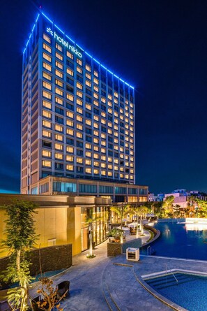 Un edificio de hotel con piscina y zona de estar al aire libre.