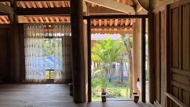 A traditional wooden room with a view of a garden. - Yasmin Farm (Linh Son)