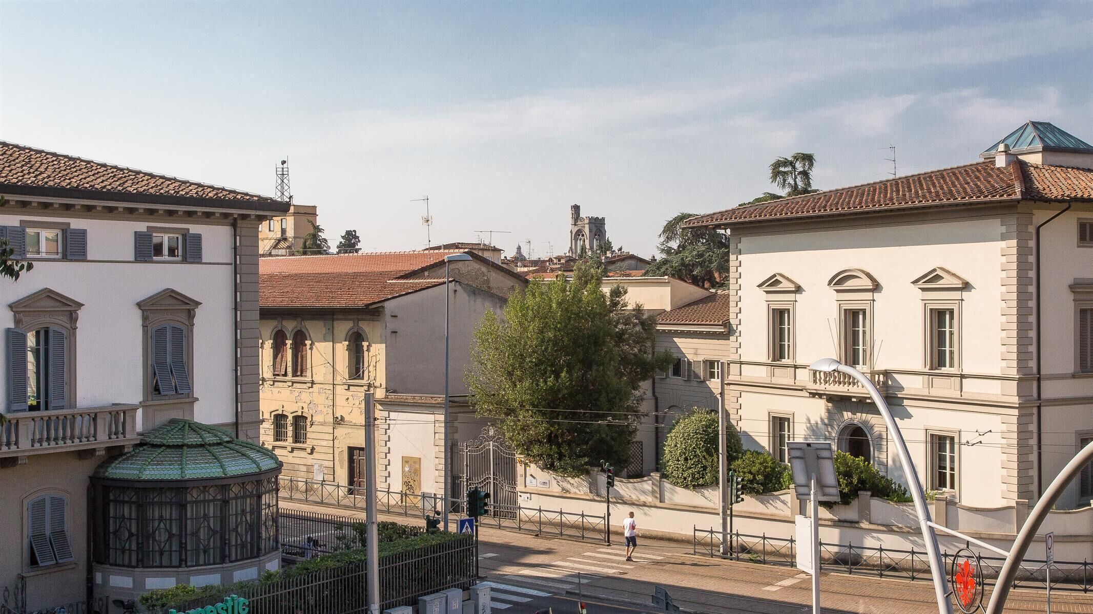 A street view with historic buildings, a green dome structure, and a pedestrian crossing.