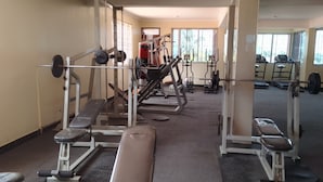 A gym with various exercise equipment, including benches and weight machines. - Nemarts Hotel (Dar es Salaam)