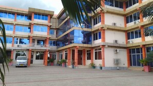 A multi-story building with a central courtyard, potted plants, and a parked vehicle. - Nemarts Hotel (Dar es Salaam)