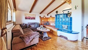 A cozy living room with a sofa, a coffee table, and a blue cabinet. - Nice apartment for 4 people with WIFI, TV and balcony (Wildschönau)