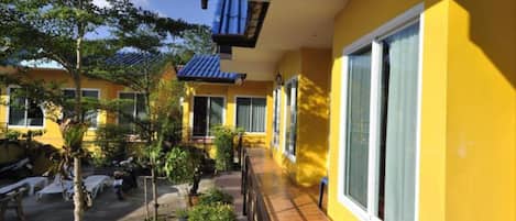 A yellow building with large windows and a covered walkway.