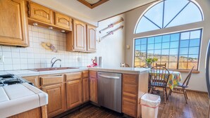 Una cocina con armarios de madera, lavavajillas y un ventanal con vistas.