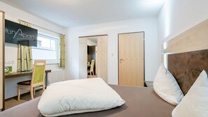 A modern hotel room with a bed, a desk, and a chair. There is a sign on the wall that reads "lun Apart". - Cosy apartment for 2 people with WIFI, TV and pets allowed (Solden)
