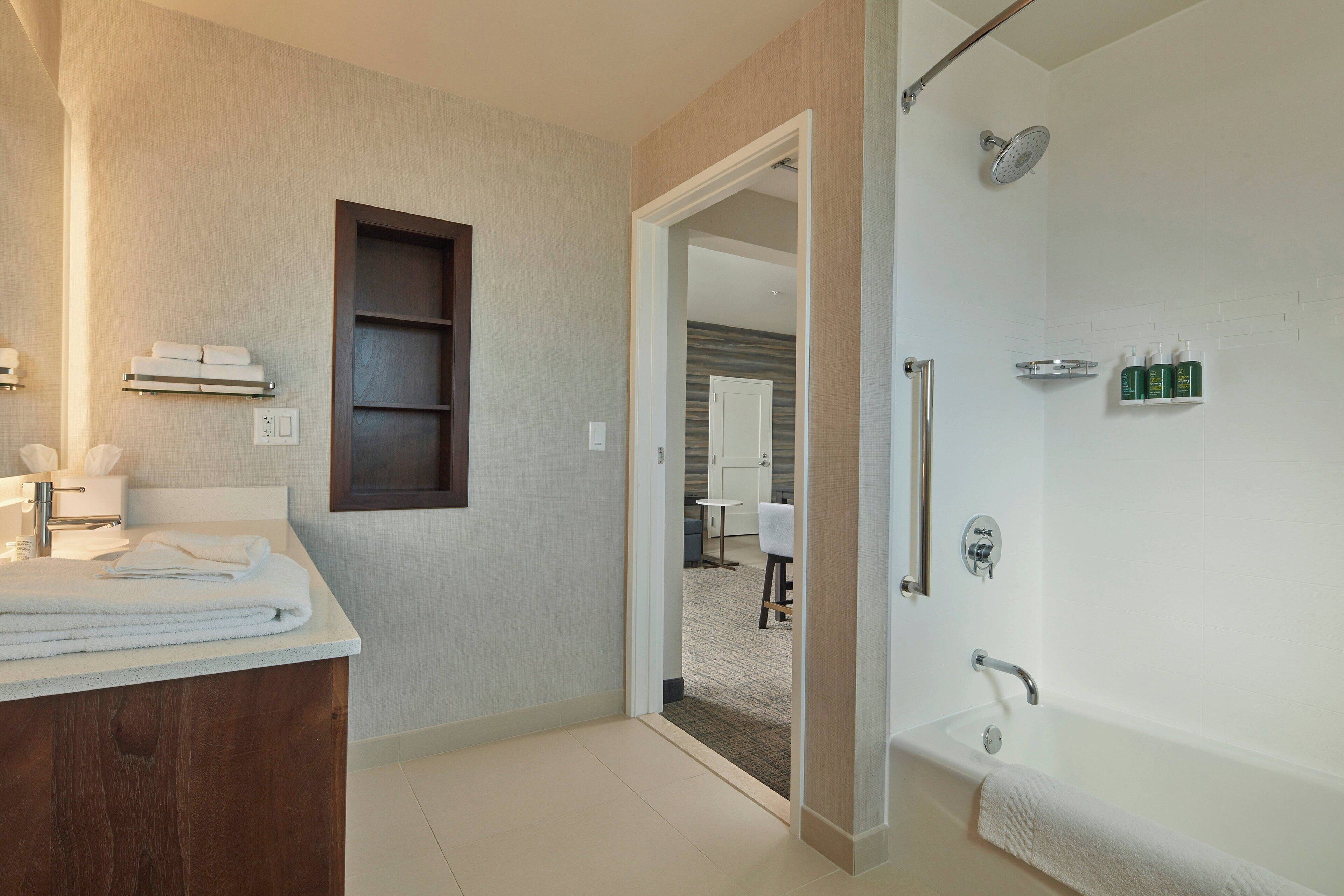Un baño moderno con una bañera grande, una ducha y un tocador con espejo.