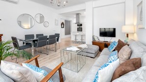 Een moderne woonkamer met een bank, salontafel en een eethoek.