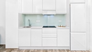 Een moderne keuken met witte kasten, een roestvrijstalen spoelbak en een inbouwoven.
