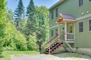 A green building with a porch and a staircase leading to the entrance. - Rustic 3-Story Pittsburg Cabin w/ Lake & Mtn Views (Pittsburg)