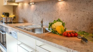 Eine moderne Küche mit Granit Arbeitsplatte, Edelstahlspüle und weißen Schränken.