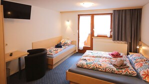 A hotel room with a bed, a desk, a chair, a TV, and a window with curtains. - Nice apartment for 5 guests with WIFI, TV, patio and pets allowed (Gaschurn)