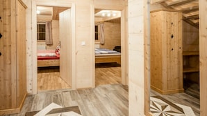 A wooden interior with a hallway leading to a bedroom with a bed and a window. - Cosy apartment in villa for 18 guests with WIFI, pool, TV, terrace and pets allowed (Klazenberg)