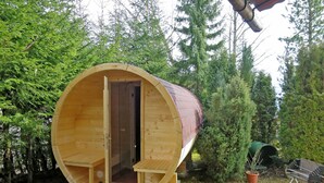Una casetta di legno con una porta, un piccolo portico e un camino.