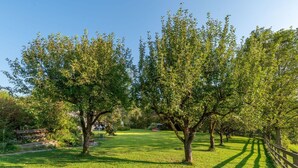 A park with a grassy area, trees, a wooden fence, and a bench. - Cosy apartment for 4 guests with WIFI, TV, patio and pets allowed (Dietrichstein)