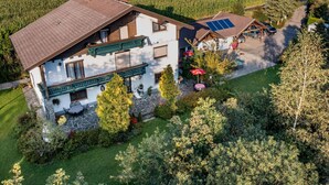A two-story house with a sloped roof, a stone foundation, and a balcony with a green railing. - Cosy apartment for 4 guests with WIFI, TV, patio and pets allowed (Dietrichstein)