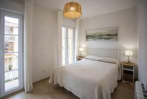 1 dormitorio y tabla de planchar con plancha