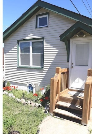 Simple, single-story home with a front porch and garden.