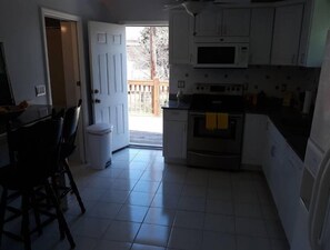 Enjoy meals in this kitchen with a stainless steel oven, dining table, and comfortable seating.