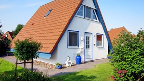 A house with a steeply pitched roof, a small porch, and a front door.