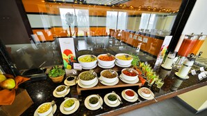 A buffet with various food options and a beverage station. - Cygnett Inn Sea View (Kanthi)