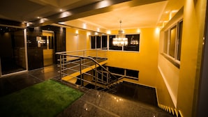 A modern interior with a staircase, a chandelier, and a green carpet. - Cygnett Inn Sea View (Kanthi)