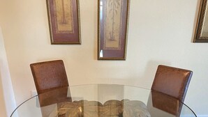 A round glass table surrounded by four brown leather chairs. - Waterfront home w/dock-Jon boat, Kayaks & fishing poles included! (Port Richey)