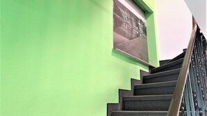 A staircase with a green wall and a framed picture. - Hotel Austria Stuttgart-City (Stuttgart)