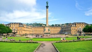 A large, historic building with a central monument, surrounded by well-maintained lawns and pathways. - Hotel Austria Stuttgart-City (Stuttgart)