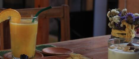 A table with a glass of orange juice, a sandwich, and a glass of milk.