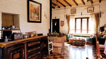 A rustic room with a checkered floor, wooden furniture, and a stone fireplace.