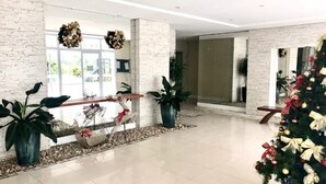 Eine großzügige Lobby mit Weihnachtsbaum, Topfpflanzen und einer dekorativen Bank.