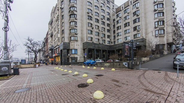 Ein mehrstöckiges Gebäude mit einem gepflasterten Platz davor.