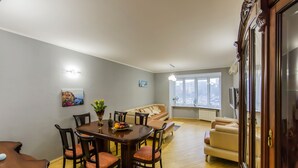 Ein Essbereich mit Holztisch und Stühlen, einer Couch und einem Fenster mit Blick.