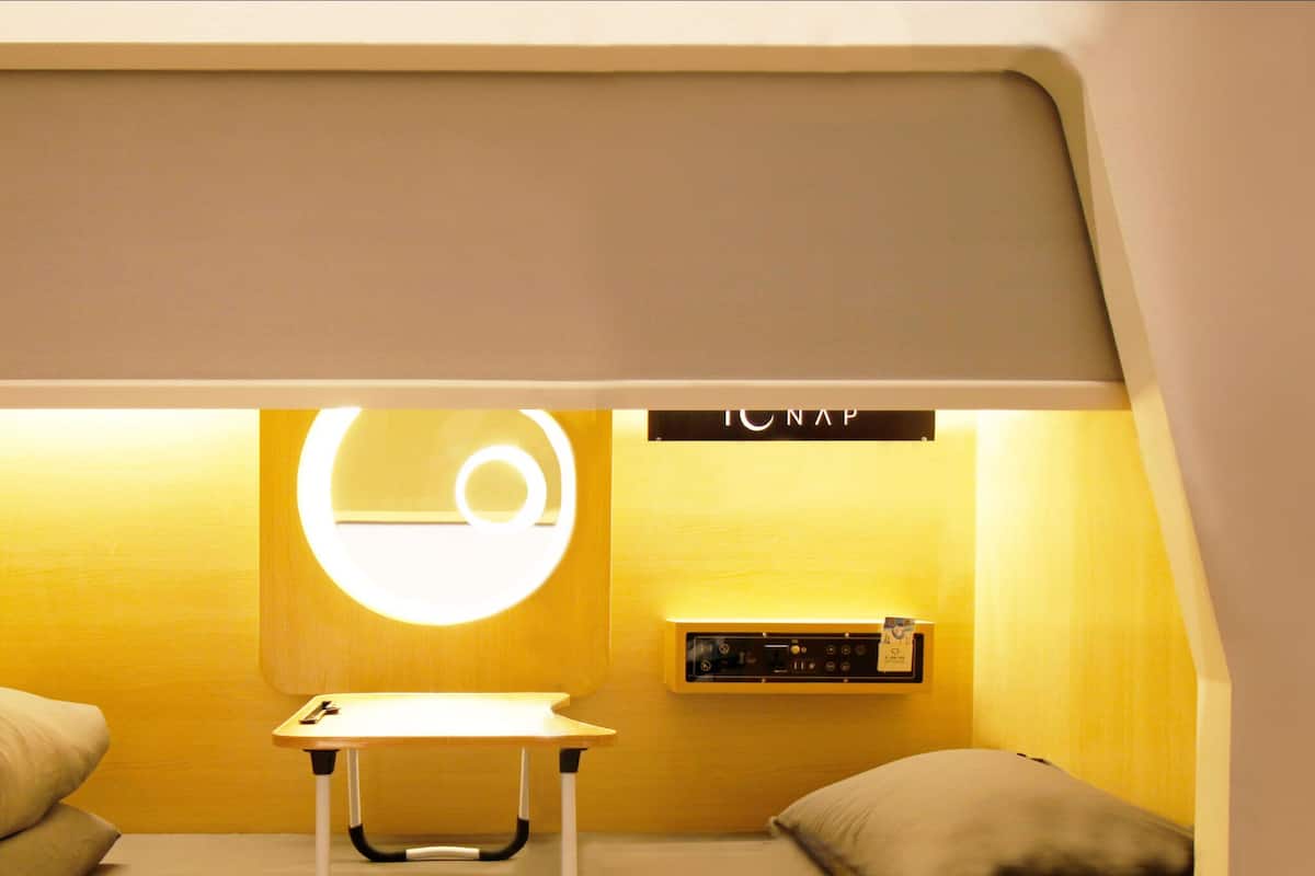 Ein gemütlicher Raum mit einem Bett, einem kleinen Tisch und einer Wandladestation.