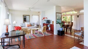 A spacious living area with a dining table, chairs, a sofa, and a ceiling fan. - This stunning View Could Be Yours (West End)