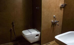 Un baño con inodoro, ducha y lavabo.