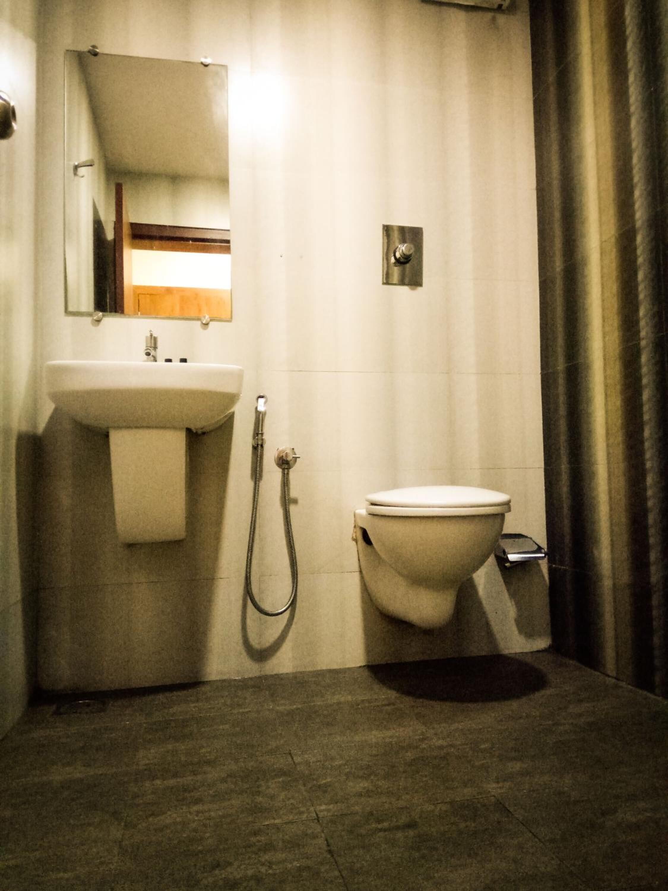 Ein Badezimmer mit Waschbecken, Spiegel, Toilette und Dusche.