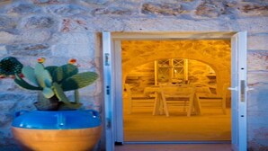 Una entrada de paredes de piedra con una puerta de madera que da a un espacio interior.