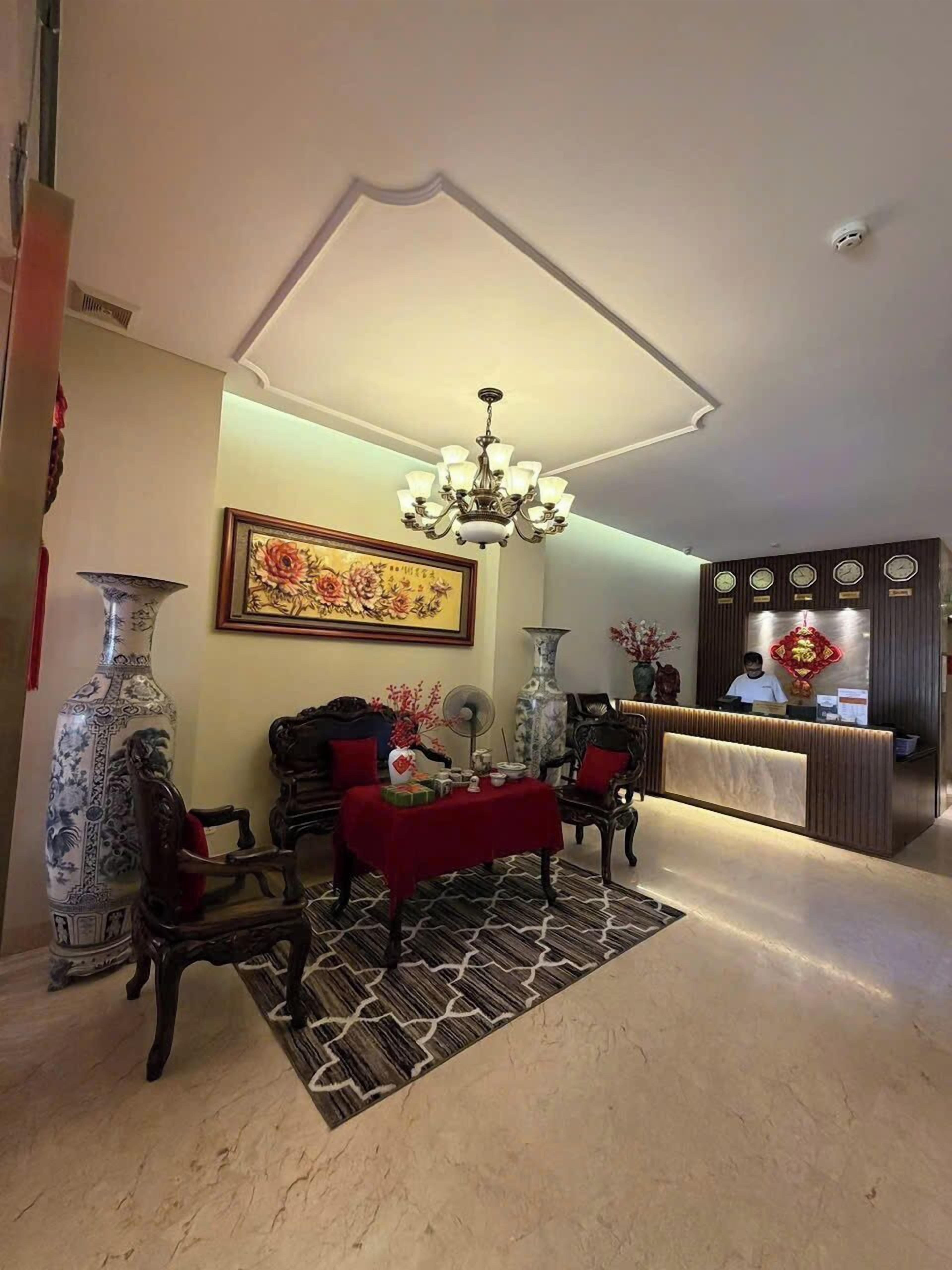 Un hall d’entrée spacieux, agrémenté d’un lustre, d’un comptoir de réception et d’une décoration de style traditionnel.