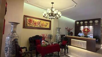 Un hall d’entrée spacieux, agrémenté d’un lustre, d’un comptoir de réception et d’une décoration de style traditionnel.