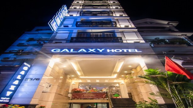 The Galaxy Hotel entrance with a Coca-Cola banner, a staircase, and a flag. - GALAXY AIRPORT HOTEL (Ho Chi Minh City)