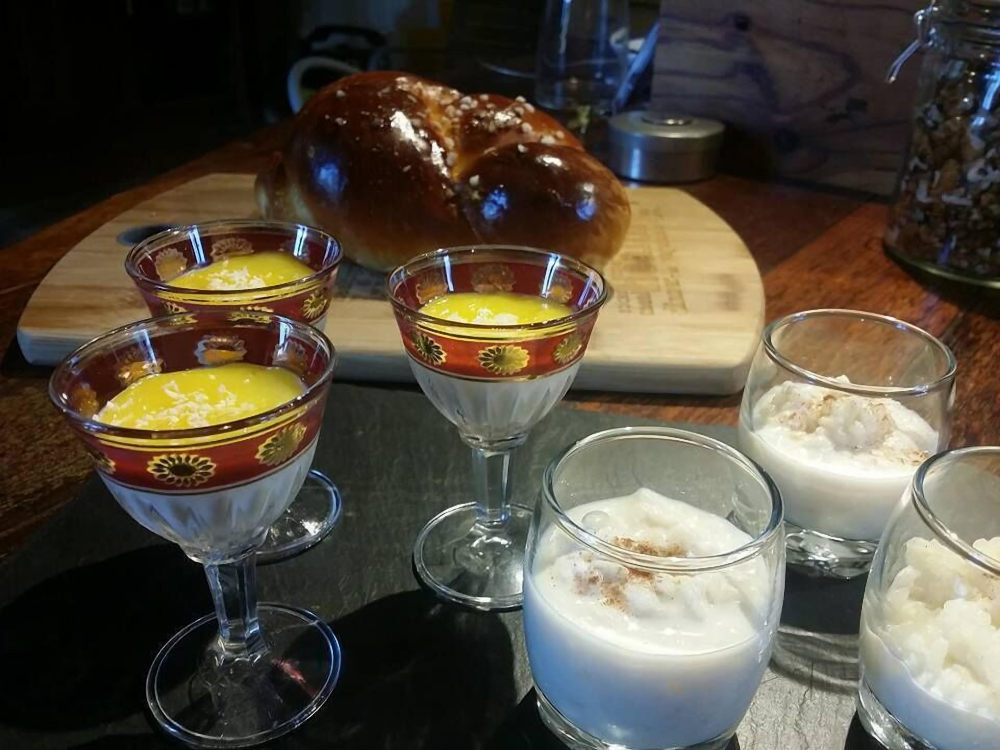 A table with various food items including a loaf of bread, bowls of soup, and glasses of milk.