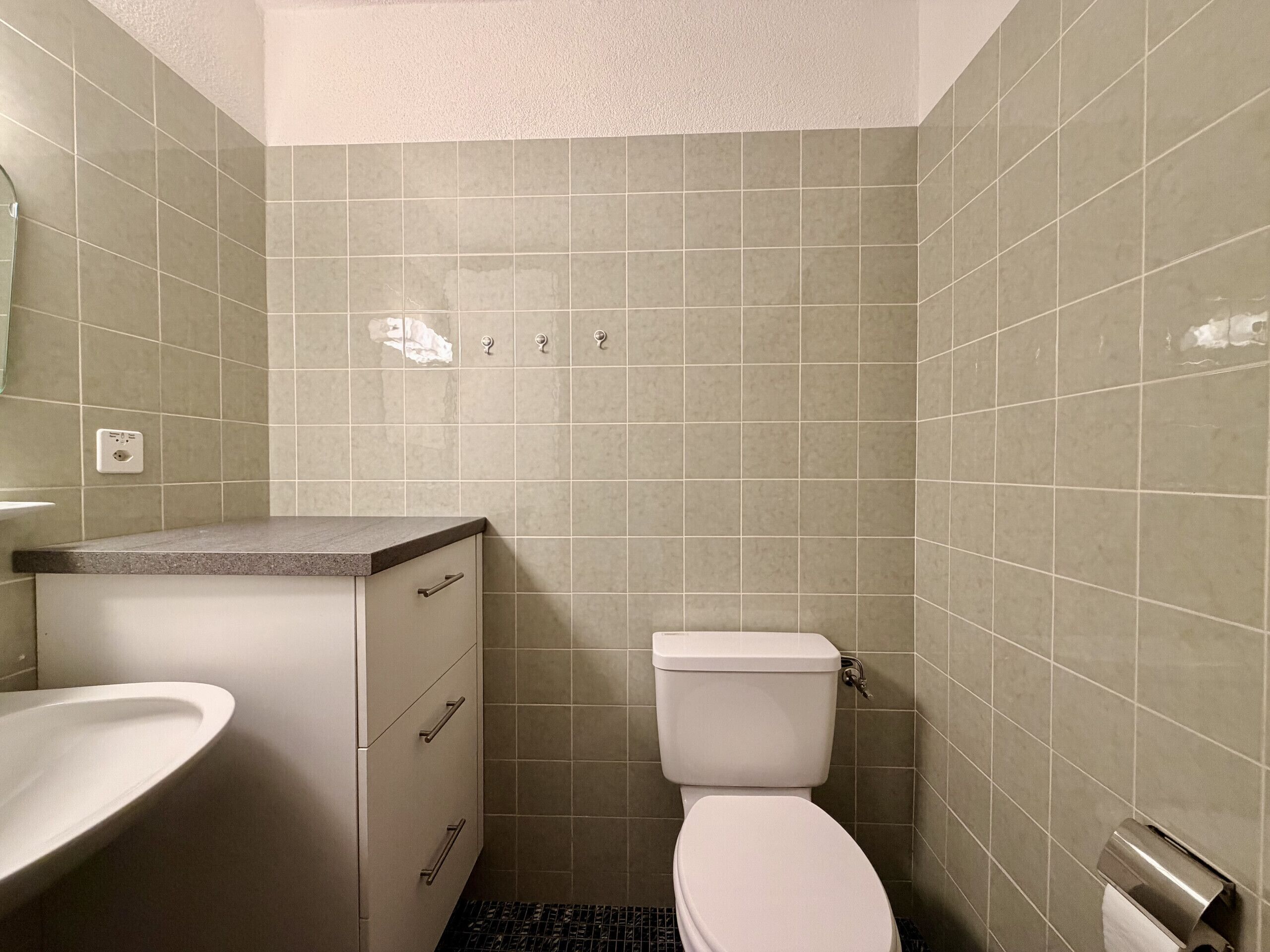 Baño con inodoro, lavamanos y armario.