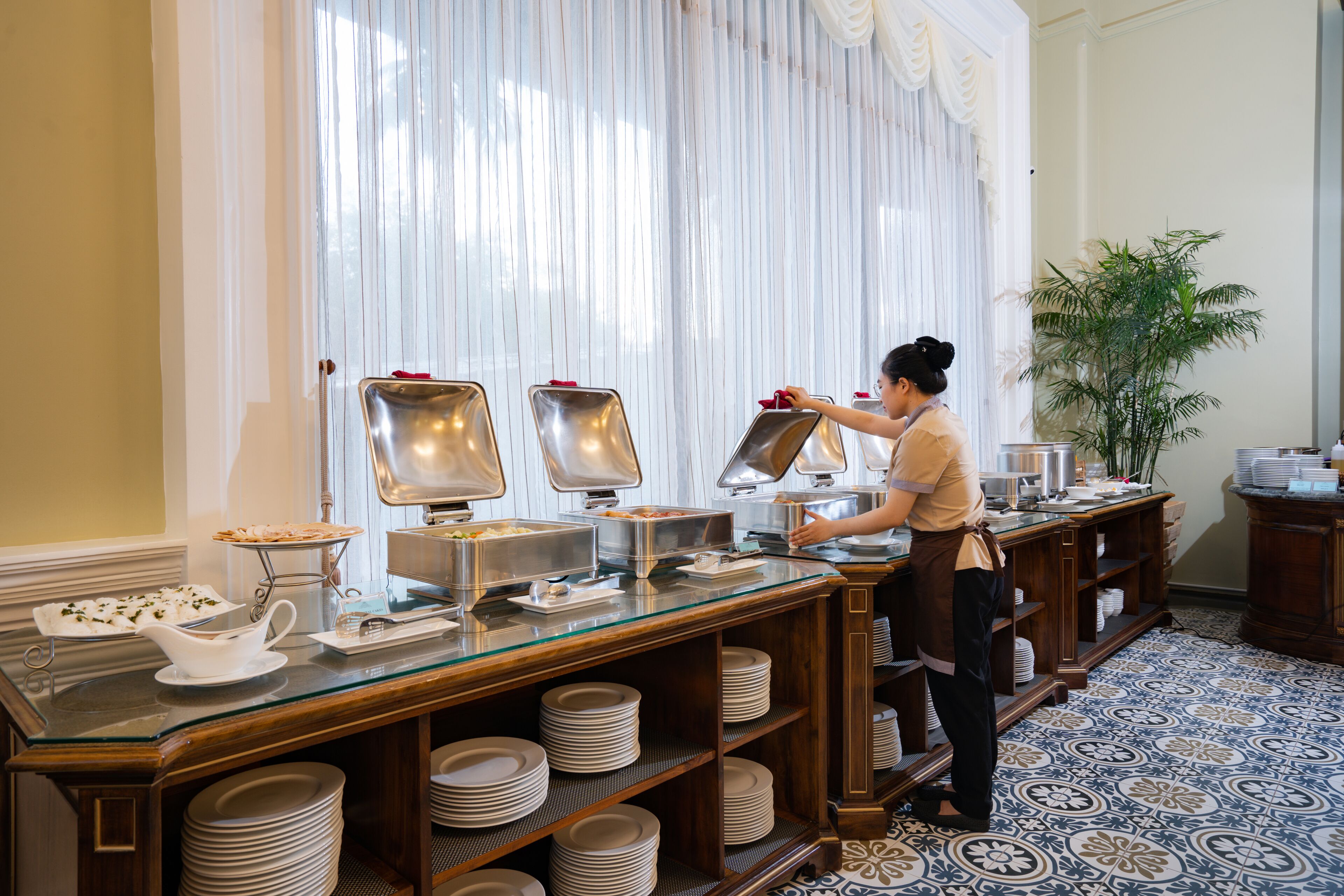 A buffet setup with multiple serving stations, a variety of dishes, and neatly stacked plates.
