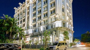 A multi-story hotel with a classical architectural style, featuring large windows and ornate detailing.
