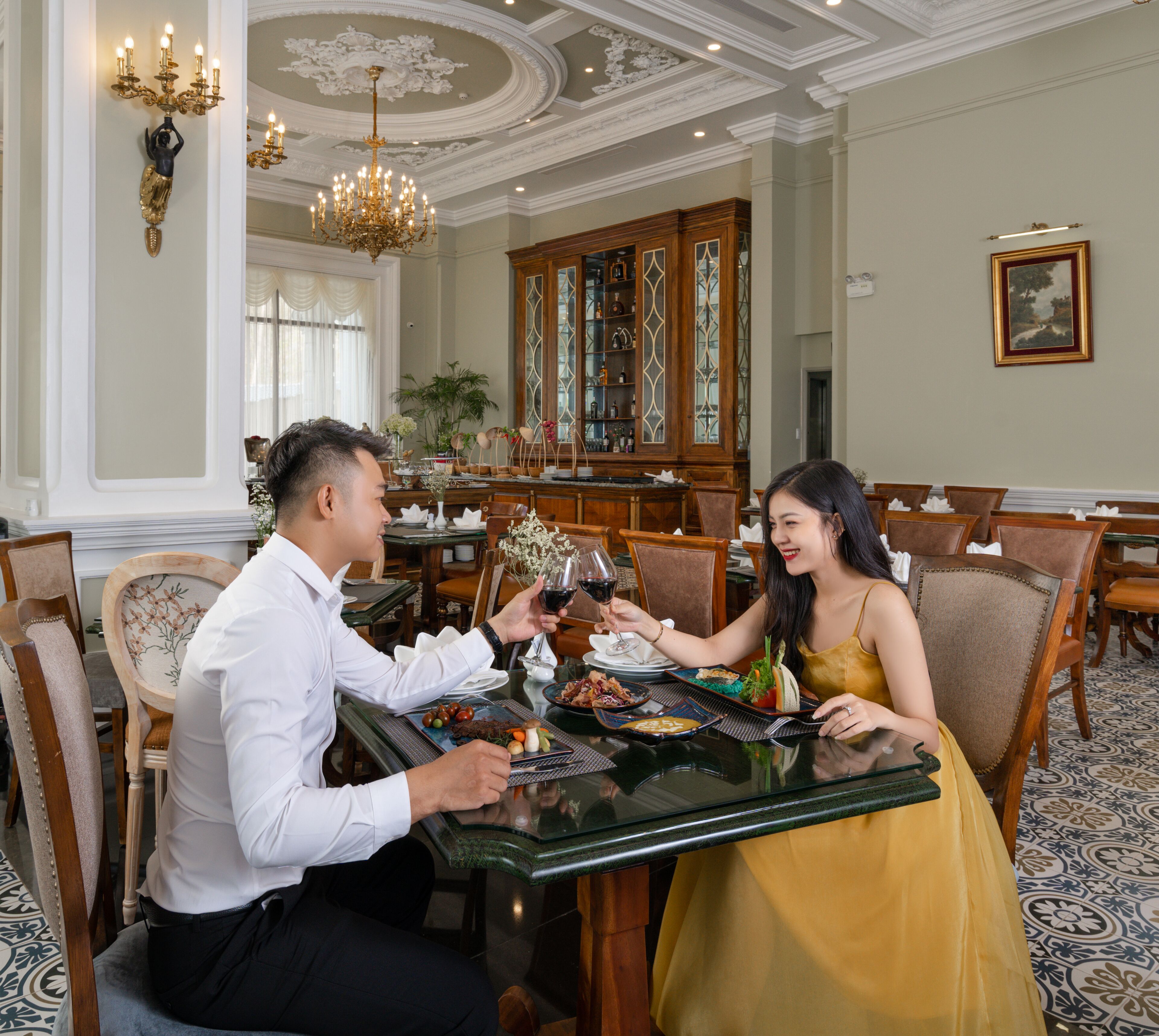 A dining room with a chandelier, wooden furniture, and a large window with curtains.