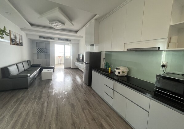 A modern kitchen with white cabinets, a black countertop, and a built-in microwave.