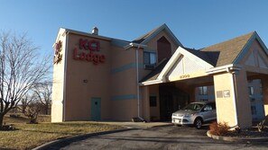 Edificio di un KCI Lodge con ingresso coperto e un'auto parcheggiata di fronte.